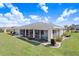 Landscaped backyard with lawn and enclosed lanai, perfect for relaxation at 303 Cranston Pl, Sun City Center, FL 33573