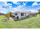Rear view of home featuring a large lawn and enclosed lanai at 303 Cranston Pl, Sun City Center, FL 33573