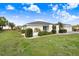 Well-manicured lawn featuring lush greenery and a charming home with a clean, white exterior and manicured bushes at 303 Cranston Pl, Sun City Center, FL 33573