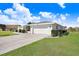 Well-maintained home with a spacious driveway, manicured lawn, and tasteful landscaping in a lovely neighborhood at 303 Cranston Pl, Sun City Center, FL 33573