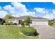 Charming home with manicured lawn, and tasteful landscaping with a freshly paved driveway in a quiet neighborhood at 303 Cranston Pl, Sun City Center, FL 33573
