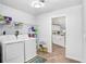 Well-lit laundry room with washer, dryer, shelving, and access to kitchen at 303 Cranston Pl, Sun City Center, FL 33573