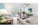 Well-lit living room featuring sofas, coffee table, and view of screened lanai at 303 Cranston Pl, Sun City Center, FL 33573
