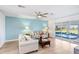 Bright living room with comfortable sofas, a ceiling fan, and view of screened pool at 303 Cranston Pl, Sun City Center, FL 33573
