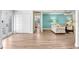 Open-concept living room with light wood flooring and a bright accent wall at 303 Cranston Pl, Sun City Center, FL 33573