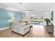 Comfortable living room with ceiling fan, sofas, and view of pool area at 303 Cranston Pl, Sun City Center, FL 33573
