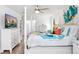 Bright main bedroom with ceiling fan, TV, and white furnishings at 303 Cranston Pl, Sun City Center, FL 33573
