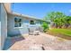 Private backyard patio with chairs, table, and lush landscaping offer a relaxing outdoor living space at 3310 W Swann Ave, Tampa, FL 33609