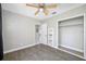 Simple bedroom with wood-look floors, closet, and a ceiling fan with overhead lighting at 3310 W Swann Ave, Tampa, FL 33609