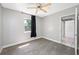 Cozy bedroom with wood-look floors, ceiling fan, and a view to the backyard at 3310 W Swann Ave, Tampa, FL 33609