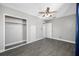 Neutral bedroom features wood-look flooring, built-in storage, and a ceiling fan at 3310 W Swann Ave, Tampa, FL 33609