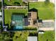 Aerial view of home with screened pool, solar panels, and manicured lawn at 39142 Kendell Dr, Zephyrhills, FL 33542