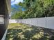 The backyard features green grass, a white fence, and green trees at 405 Laguna Mill Dr, Ruskin, FL 33570