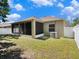 A rear exterior view of the home with a screened-in patio and a green lawn at 405 Laguna Mill Dr, Ruskin, FL 33570