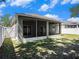 The screened-in back patio features a concrete patio and a white fence at 405 Laguna Mill Dr, Ruskin, FL 33570