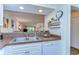 A double kitchen sink with white cabinets and an open view of the living room at 5019 Mill Pond Rd # 3128, Wesley Chapel, FL 33543