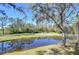 Scenic view of a tranquil pond, reflecting the surrounding trees and blue sky at 5019 Mill Pond Rd # 3128, Wesley Chapel, FL 33543