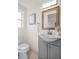 Elegant half bath features a new, stylish gray vanity, mirror, toilet and fixtures at 5801 Dartmouth N Ave, St Petersburg, FL 33710