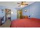 Spacious bedroom with blue walls, ceiling fan, and views into a walk-in closet and bathroom at 5820 N Church Ave # 148, Tampa, FL 33614