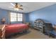 Bedroom featuring a ceiling fan, window with blinds, and a red bedspread on a bed frame at 5820 N Church Ave # 148, Tampa, FL 33614
