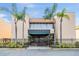 The building's entryway is framed by palm trees and a dark metal fence at 5820 N Church Ave # 148, Tampa, FL 33614