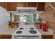 View from kitchen over stovetop looking to the living area and large glass doors providing ample light at 5820 N Church Ave # 148, Tampa, FL 33614