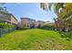 A lush green backyard with a fence, lawn and mature trees at 6338 Springline Pl, Apollo Beach, FL 33572