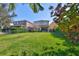 Backyard view showing the yard, fence, and home's exterior with sliding glass doors leading to a patio at 6338 Springline Pl, Apollo Beach, FL 33572