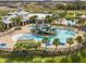 Aerial view of a community pool with a slide, palm trees, and a clubhouse overlooking the area at 6338 Springline Pl, Apollo Beach, FL 33572