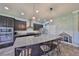 Modern kitchen featuring stainless steel appliances, dark cabinets, granite counters, and a spacious center island at 6338 Springline Pl, Apollo Beach, FL 33572