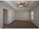 Neutral bedroom featuring carpeted floor, ceiling fan, tray ceiling and a window with natural light at 6527 Grapewood Rd, Spring Hill, FL 34609