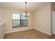 Bright dining room featuring wood floors, a chandelier, and a large window at 6527 Grapewood Rd, Spring Hill, FL 34609
