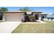 Charming single-story home with a well-manicured front yard and a two-car garage at 6527 Grapewood Rd, Spring Hill, FL 34609