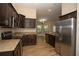 Modern kitchen with stainless steel appliances, granite countertops, and dark wood cabinets at 6527 Grapewood Rd, Spring Hill, FL 34609