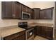 Updated kitchen with granite countertops, stainless steel appliances, and dark cabinets at 6527 Grapewood Rd, Spring Hill, FL 34609