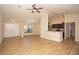 Bright and airy living room featuring wood floors, a ceiling fan, and a view into the kitchen at 6527 Grapewood Rd, Spring Hill, FL 34609