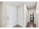 Hallway with two white doors leading to different rooms, a utility closet, and a peek into the bathroom at 7200 Sunshine Skyway S Ln # 16G, St Petersburg, FL 33711