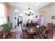 Warm dining room with a dark wood table, wood floors, and decorative lighting at 8404 White Poplar Dr, Riverview, FL 33578