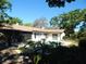 Inviting backyard featuring a sparkling pool, covered patio, and lush landscaping, perfect for outdoor entertaining at 908 N Knight St, Plant City, FL 33563