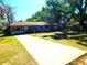 Lovely single-story house with a long driveway and verdant lawn framed by mature trees at 908 N Knight St, Plant City, FL 33563