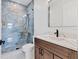 Modern bathroom featuring a glass shower with blue tile, and a marble countertop sink at 9514 Snapper Cir, Port Charlotte, FL 33981
