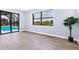 Spacious bedroom with wood floors, large window, and sliding glass doors to the pool area at 9514 Snapper Cir, Port Charlotte, FL 33981