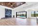 Open living room with wood-look floors, fireplace, and access to the outdoor pool area at 9514 Snapper Cir, Port Charlotte, FL 33981