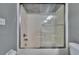 Clean bathroom featuring a shower-tub combination with sliding glass doors and a showerhead at 9526 Newdale Way # 101, Riverview, FL 33578