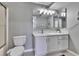 Well-maintained bathroom featuring a toilet, vanity, sink, cabinet space, and a large mirror at 9526 Newdale Way # 101, Riverview, FL 33578