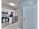 Bright kitchen with stainless steel appliances and white cabinets next to the front door at 9526 Newdale Way # 101, Riverview, FL 33578