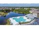 Community pool and clubhouse overlooking the lake, surrounded by lush landscaping and visitor parking at 9526 Newdale Way # 101, Riverview, FL 33578