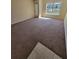 Spacious living room with plush carpeting, neutral walls, and outdoor views at 10200 Gandy N Blvd # 235, St Petersburg, FL 33702