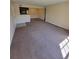 Open living area with neutral paint, carpet, and kitchen access at 10200 Gandy N Blvd # 235, St Petersburg, FL 33702