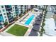 Aerial view featuring a pool and lounge area with cabanas, palm trees, and well-manicured lawns at 1120 E Kennedy Blvd # 411, Tampa, FL 33602